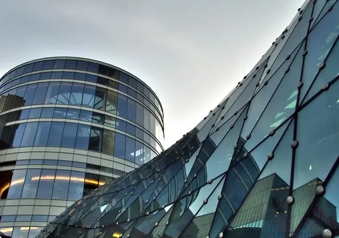 Zakrzywiona szklana fasada ilustrująca zastosowania powłok w architekturze